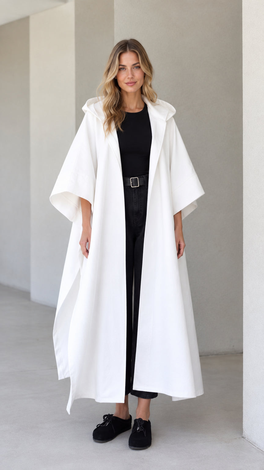 Front view of model wearing white hooded maxi canvas cape coat