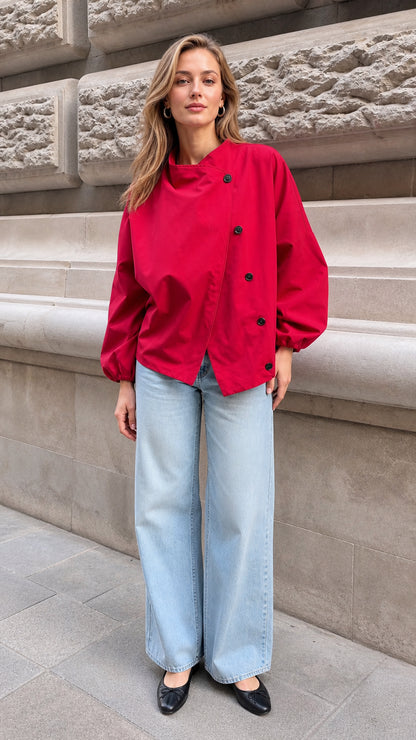 Full-length front view of model wearing the red asymmetrical button blouse with wide-leg jeans