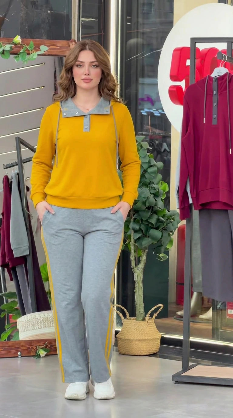 Front view of model wearing mustard yellow long sleeve top with grey collar and side-stripe sweatpants