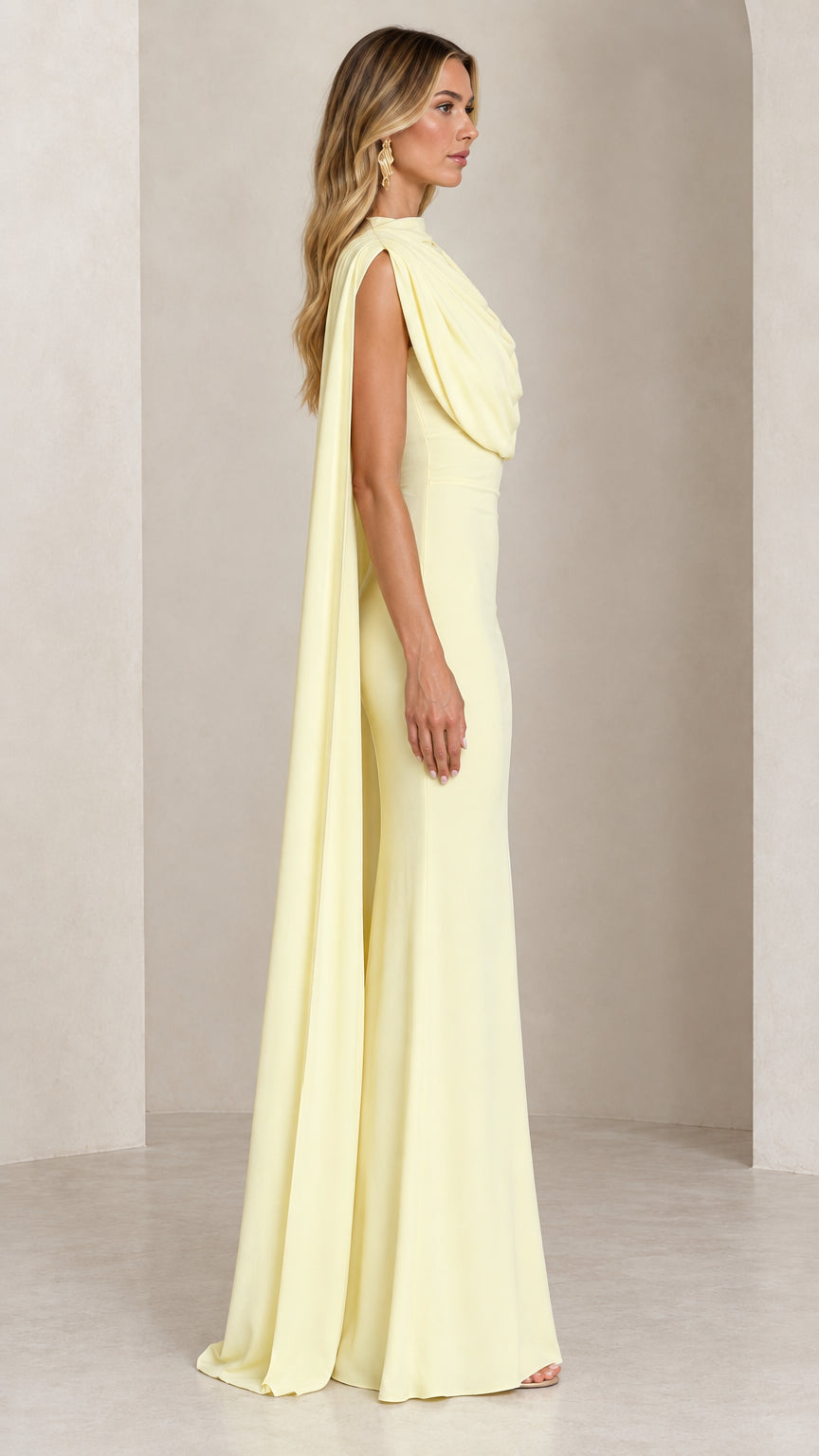 Side profile view of butter yellow sleeveless evening gown with cape detail
