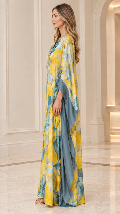 Side profile of woman in yellow floral flowing batwing caftan dress