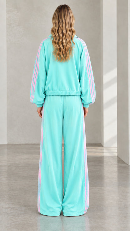 Back view of model wearing mint green zip jacket and wide leg pants set