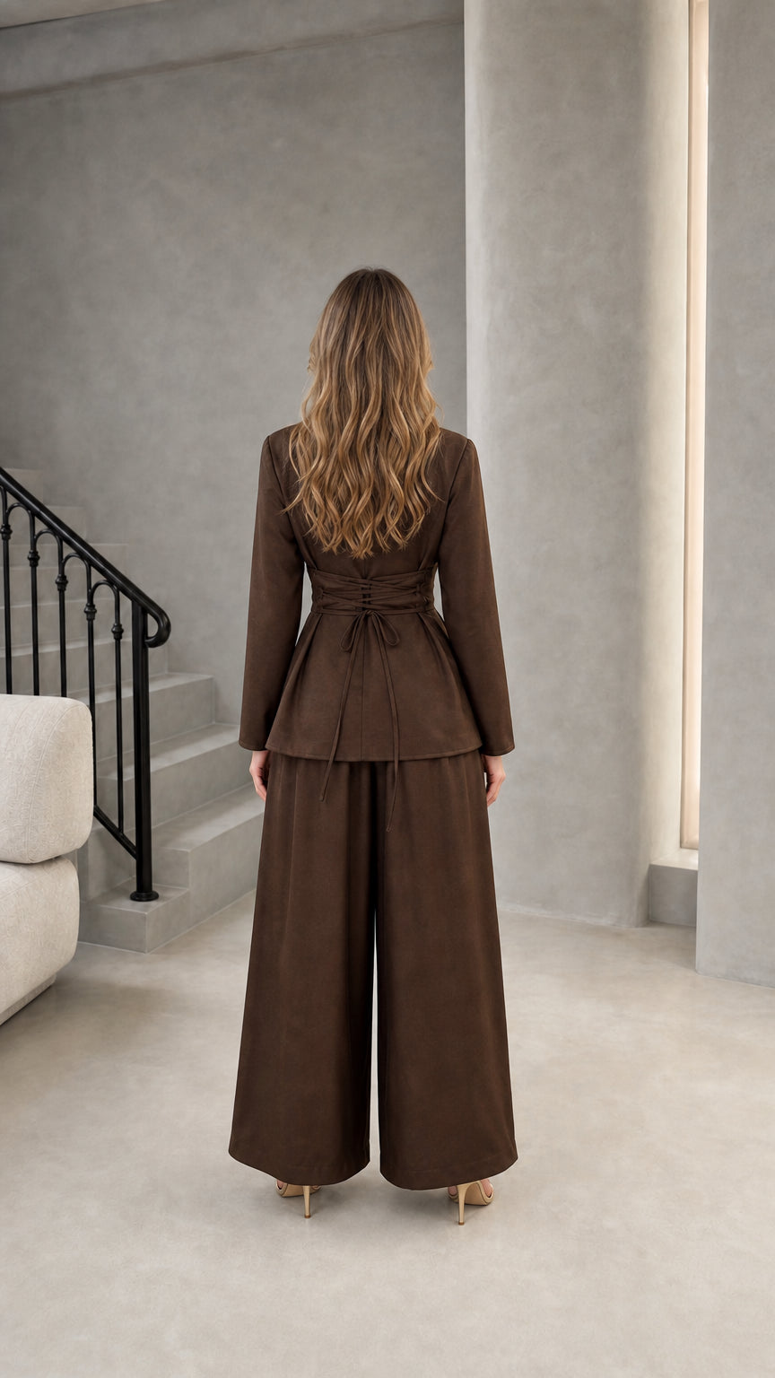 Back view of model wearing brown wrap suit set showing lace-up back detail