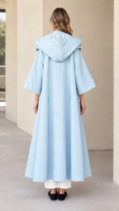 Back view of sky blue hooded maxi swing coat showing hood and full sweep