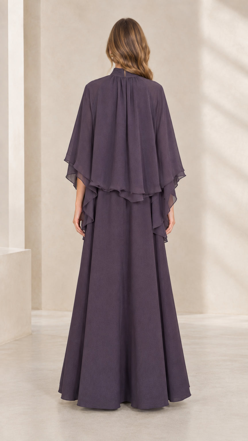 Back view of woman wearing dusty plum chiffon capelet formal dress