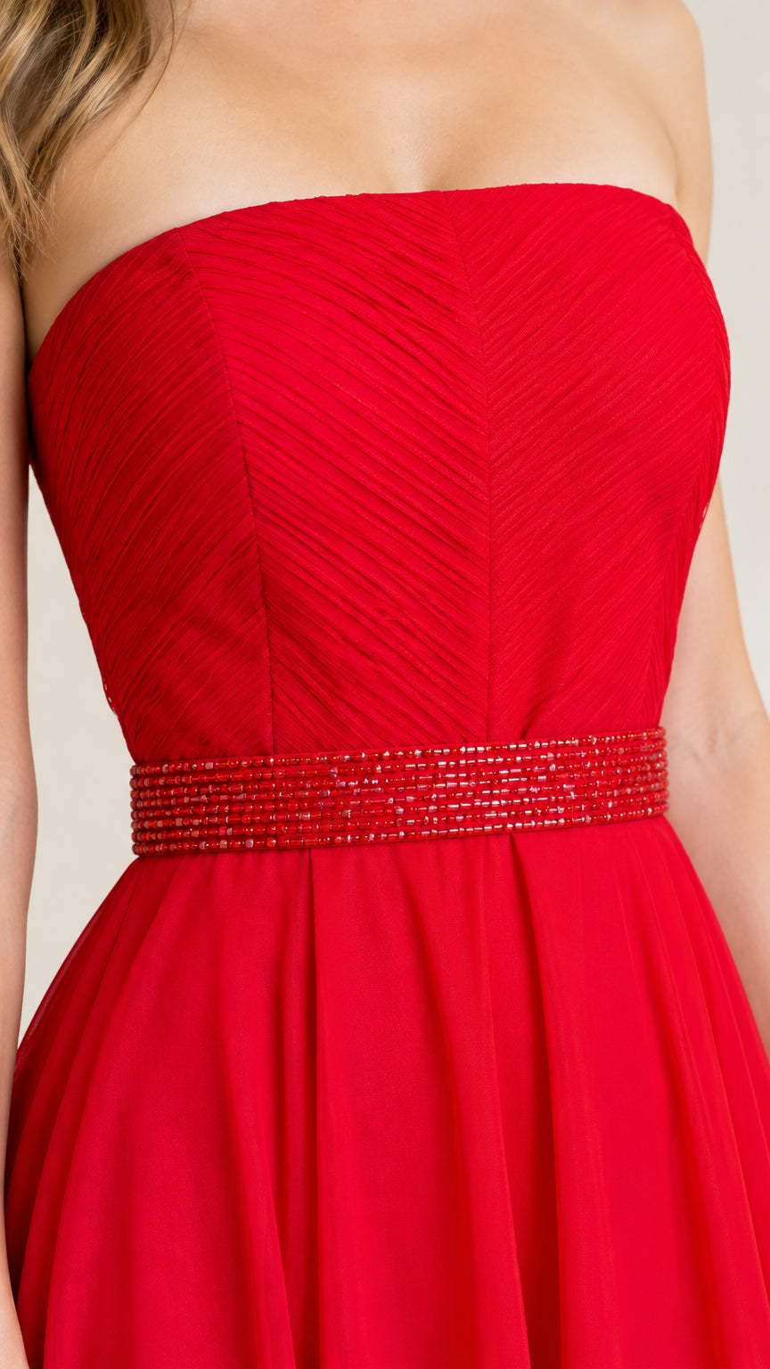 Close-up detail of red pleated strapless bodice and beaded waistband