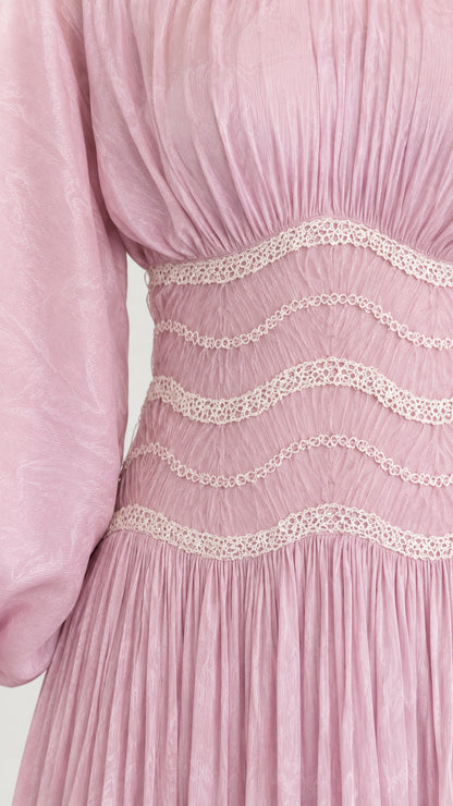 Close-up detail of wavy embroidered waistband and pleated fabric