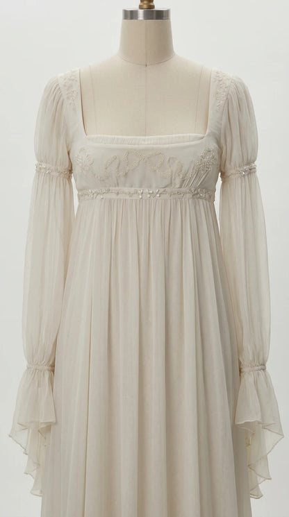 Close-up detail of embroidered bust and flared sleeves on ivory gown mannequin