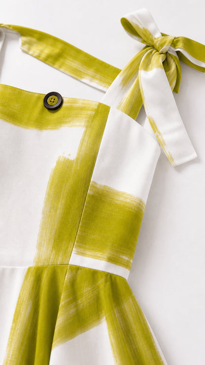Close-up of tie shoulder straps and button detail on maxi dress