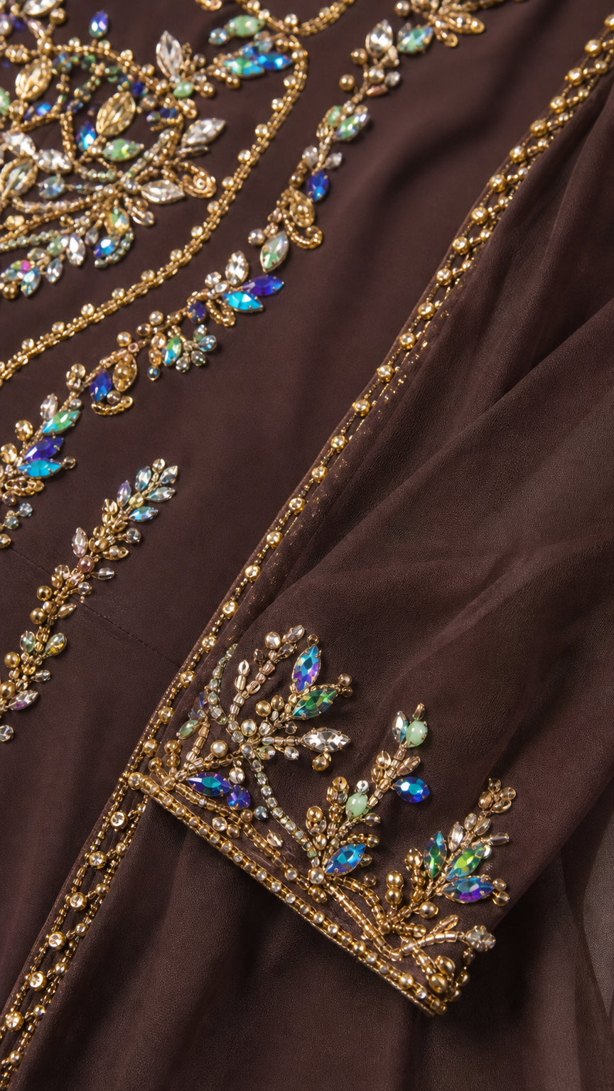 Close-up detail of intricate crystal beadwork and metallic embroidery on brown chiffon