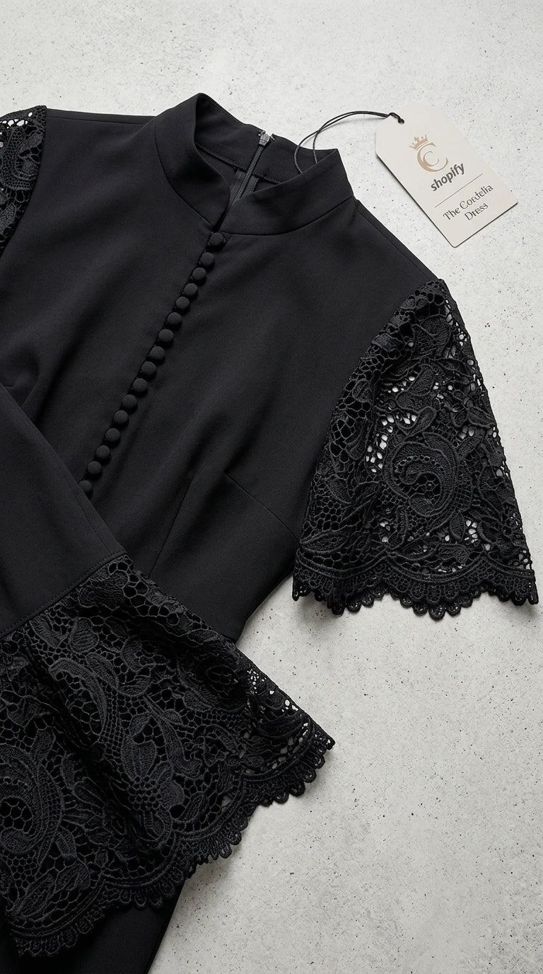 Close-up flat lay of black mock neck bodice with covered buttons and intricate lace sleeves