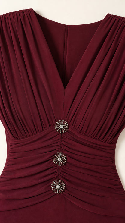 Close-up detail of pleated V-neckline and decorative crystal buttons