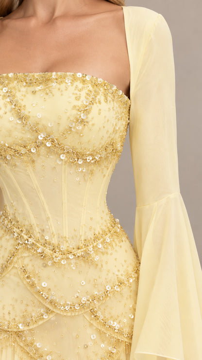 Close-up detail of delicate sequin and bead embellishments on yellow corset bodice