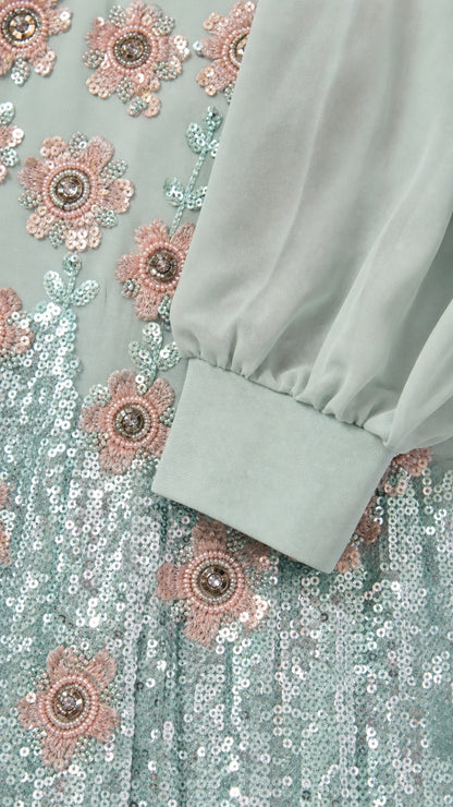 Close-up detail of mint green floral sequin embroidery and sheer sleeve cuff