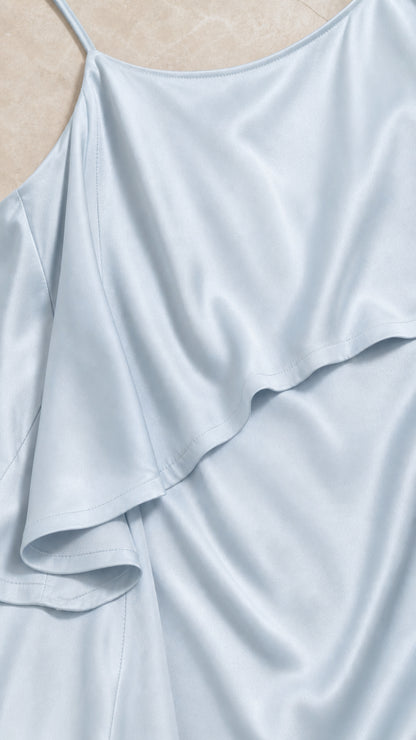 Close-up detail of light blue satin fabric and tiered ruffle seam
