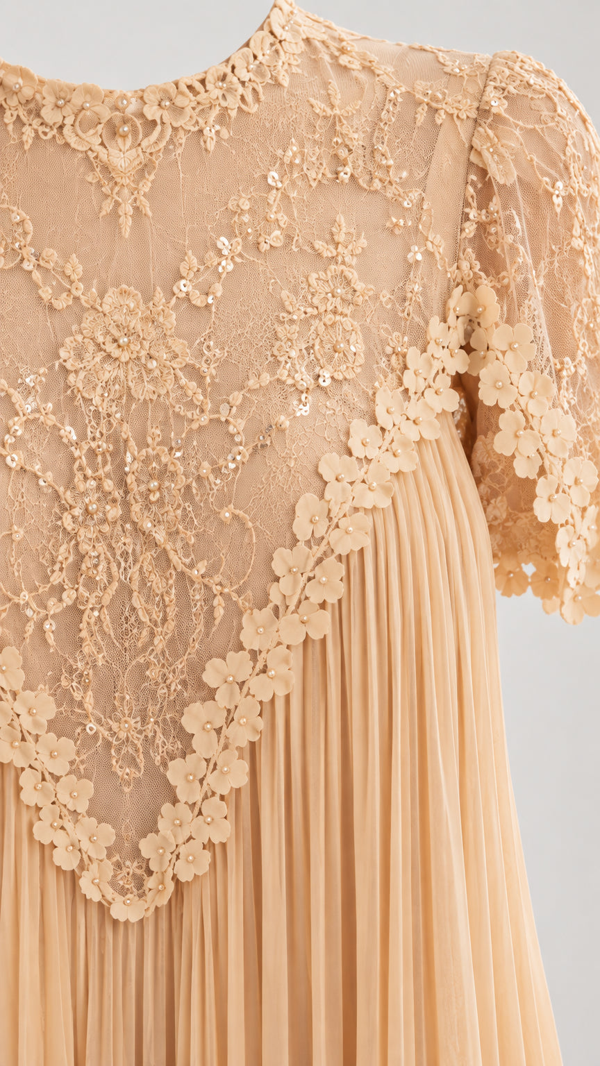 Detailed close-up of champagne floral embroidered lace yoke and sequin trim