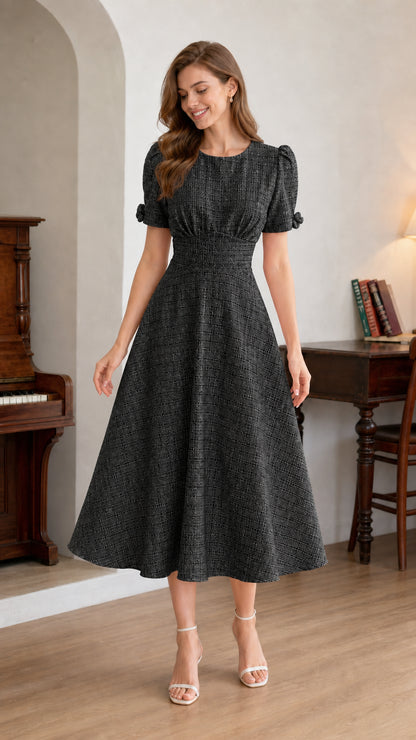 Woman wearing black textured short-sleeve A-line midi dress front view
