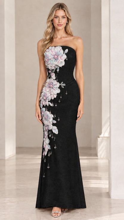 Front view of black strapless evening gown with side floral applique