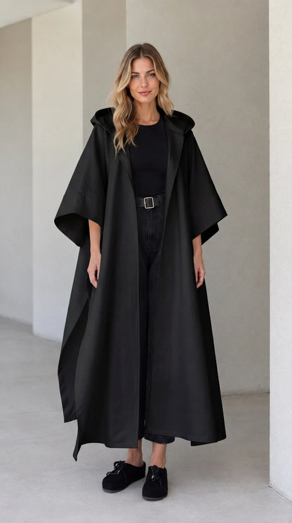 Model wearing black hooded maxi canvas cape coat with open front