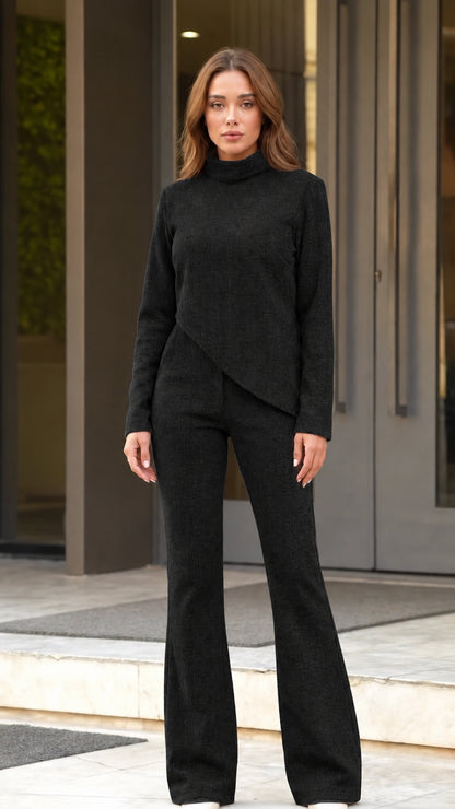 Front full view of woman wearing black asymmetric top and flared pants set