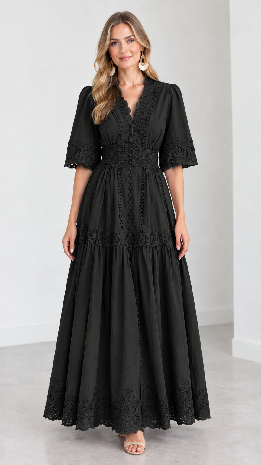 Front view of woman wearing a black V-neck lace trim tiered maxi dress