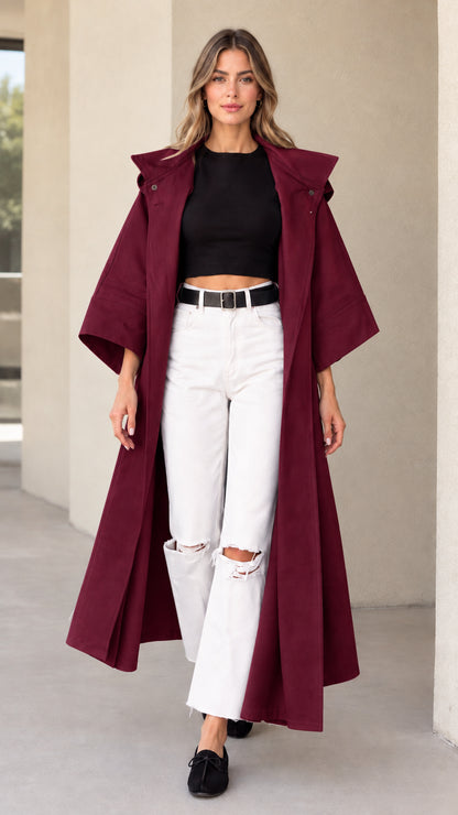 Front view of woman wearing burgundy hooded maxi duster coat